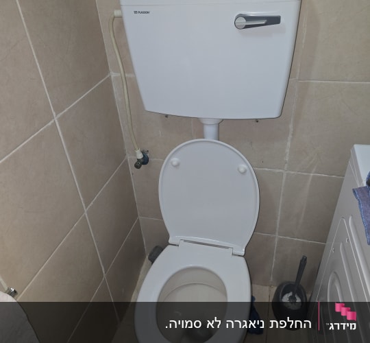 אסלה בחדר שירותים עם מברשת ניקוי